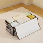 Organizador de sábanas y cobijas en tela con estampado príncipe de gales, compartimentos internos para ropa doblada.