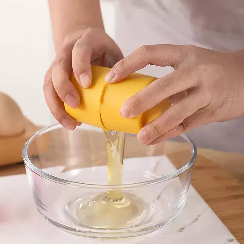 Set x2 Abre Huevos: persona separando clara de yema con extractor amarillo sobre bol de vidrio.