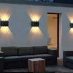 Lámpara solar aplique 6 LED exterior, ilumina pared de patio con sofá y mesa.