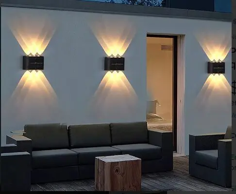 Lámpara solar aplique 6 LED exterior, ilumina pared de patio con sofá y mesa.