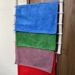 Perchero gancho con 4 paños de microfibra de colores: azul, verde, morado y rojo.