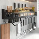 Estante organizador de cocina negro con utensilios, especias y tabla de cortar.