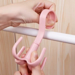 Gancho multifuncional giratorio rosado, ideal para colgar bolsos o accesorios en barras.
