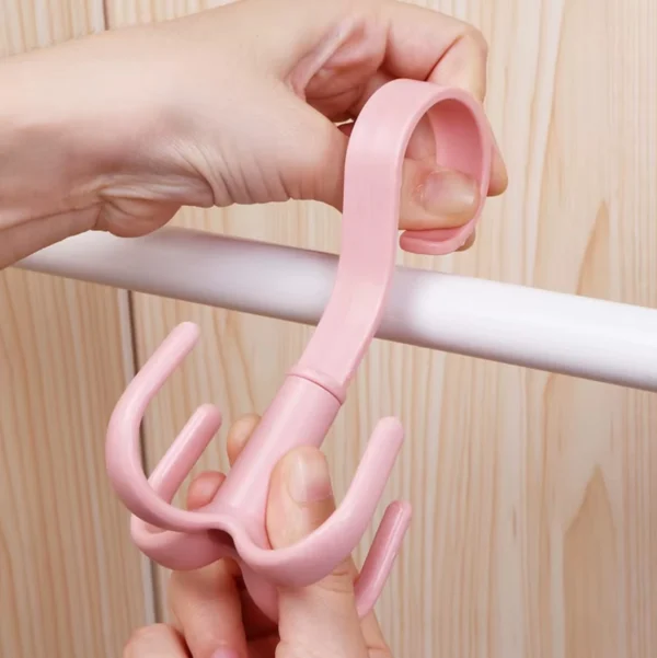Gancho multifuncional giratorio rosado, ideal para colgar bolsos o accesorios en barras.