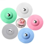 Tapón de silicona para drenaje: verde, blanco, gris, azul y rosa con detalle metálico.