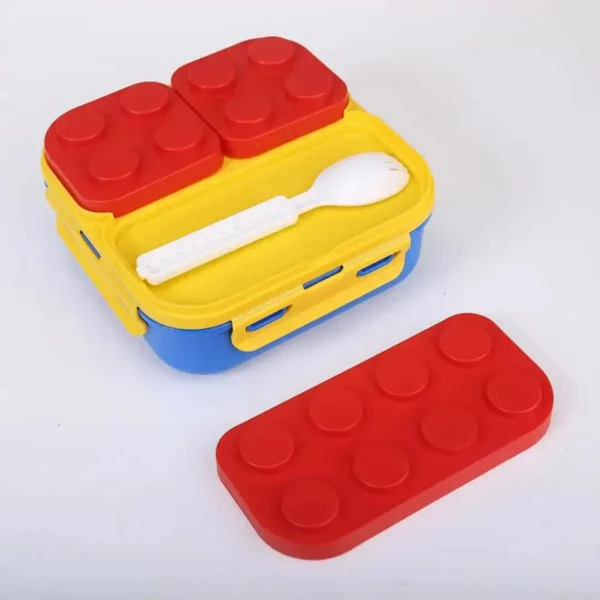 Mini lonchera tipo Lego para niños, roja y amarilla, con cubiertos blancos y tapa de bloques.