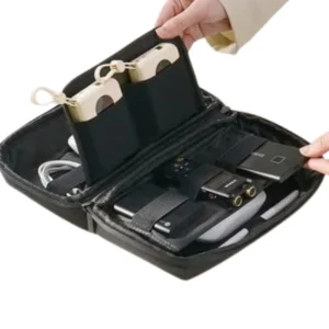 Cosmetiquera organizador de viaje negra con cámaras, cables y dispositivos electrónicos.