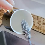 Cepillo limpiador para tazas con cerdas de silicona y colgador, ideal para lavar vajilla.