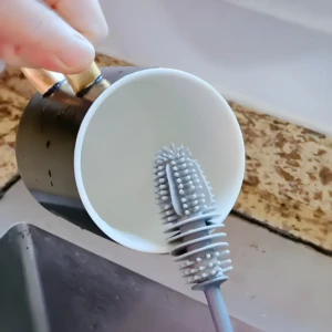 Cepillo limpiador para tazas con cerdas de silicona y colgador, ideal para lavar vajilla.