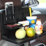 Comedero para asiento de carro con celular, frutas, bebidas y meriendas en estante organizador.