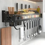 Estante organizador de cocina negro con utensilios, especias y tablas de cortar.