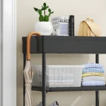 Estante zapatero multiusos con cactus, paraguas y maleta en el primer nivel.