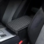 Cojín de reposabrazos acolchado negro para interior de carro, detalle en consola.