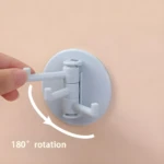 Gancho adhesivo giratorio blanco con 3 brazos, ideal para colgar objetos con rotación de 180°.
