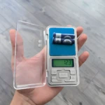 Gramera Mini Zo con dos baterías AAA en báscula digital portátil, mide 12.3 gramos.