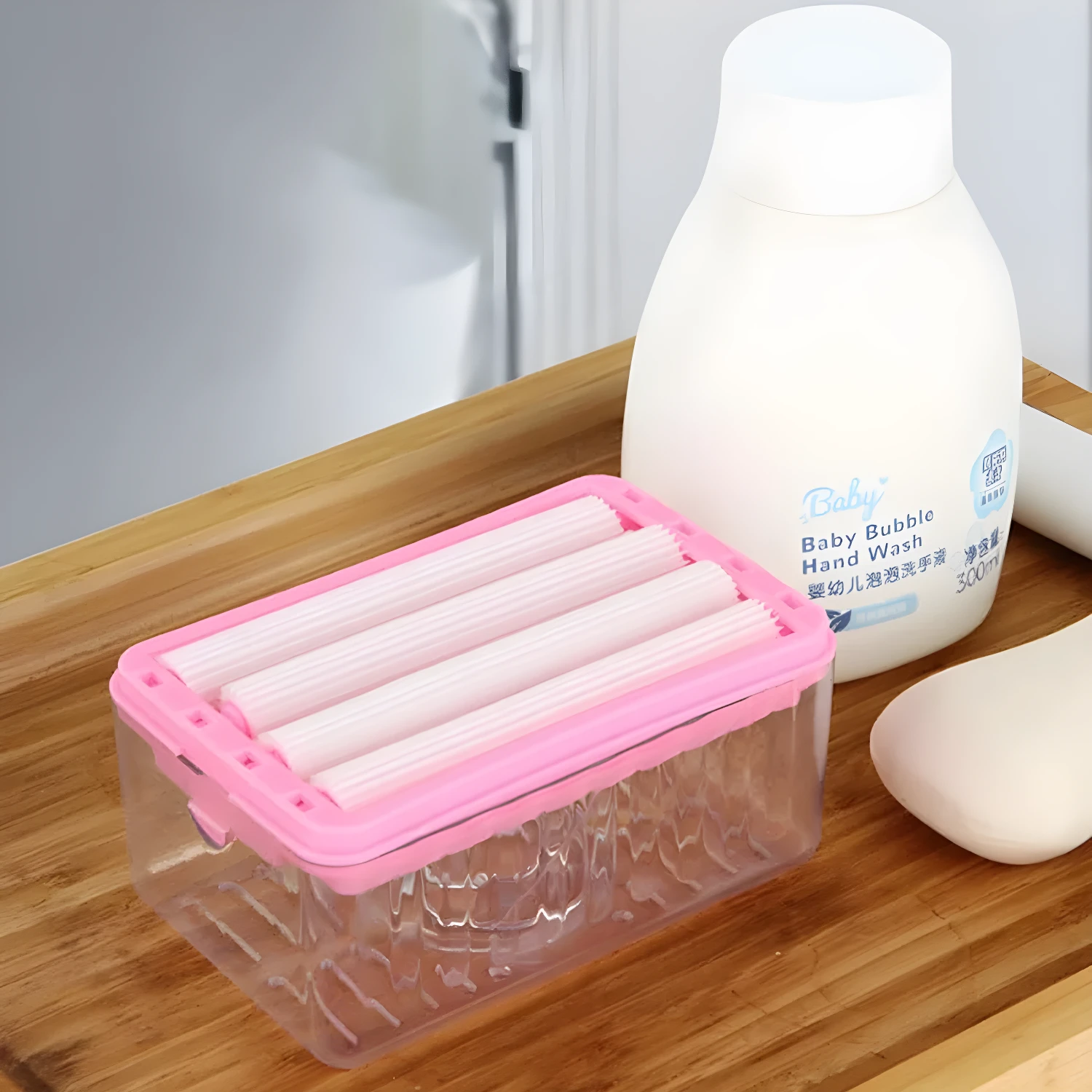 Jabonera multifuncional con rodillos, dispensador de jabón para bebés y barra de jabón sobre mesa de madera.