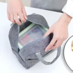 Lonchera térmica gris con recipientes de comida, ideal para llevar tu almuerzo.