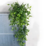Matero con planta colgante hiedra artificial verde, ideal para decorar espacios interiores.