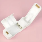 Mini selladora de bolsas blanca abierta mostrando compartimento para pilas y detalles internos.