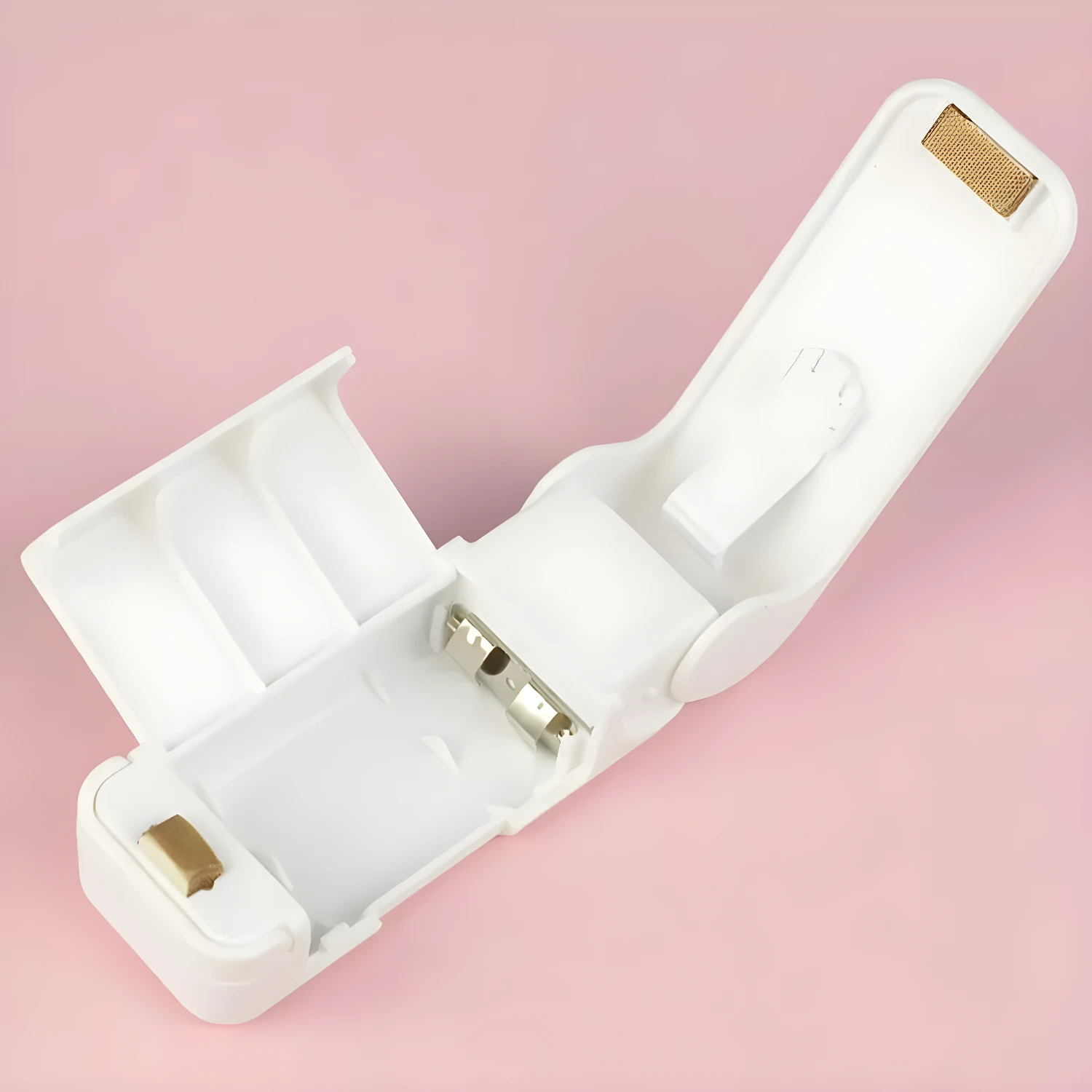 Mini selladora de bolsas blanca abierta mostrando compartimento para pilas y detalles internos.