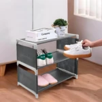 Organizador de zapatos de 3 niveles gris con tenis blancos, zapatillas rosas y plantas decorativas.