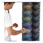 Set x2 organizador perchero para gorras: hombre blanco acomoda gorra azul en estante vertical.