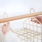 Organizador de ropa 8002 colgado de barra de madera con ganchos blancos.