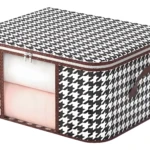 Organizador de sábanas y cobijas con estampado de pata de gallo y asas de cuero.