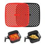 Protector silicona rojo y negro para freidora de aire, con alitas y papas.