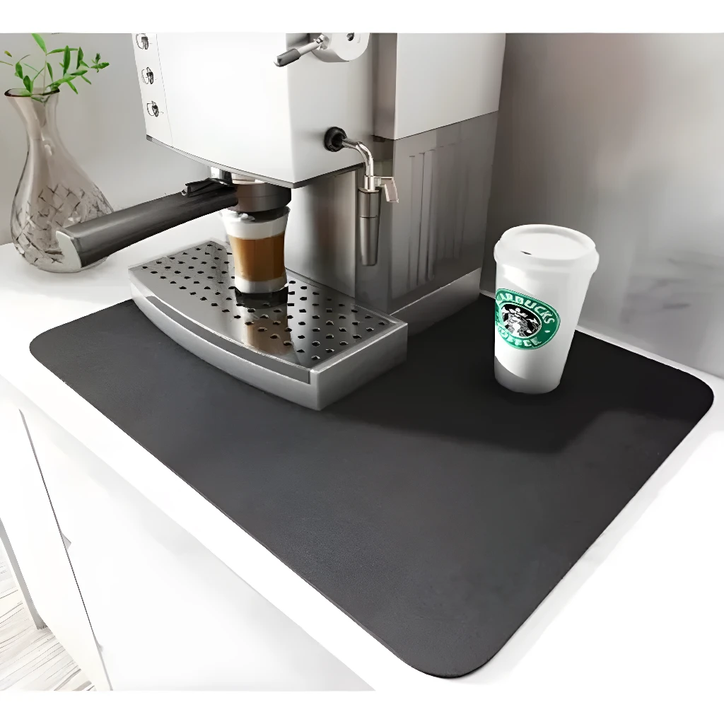 Tapete absorbente para cocina gris con cafetera, vaso Starbucks y planta.