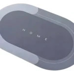 Tapete gris absorbente y antideslizante con palabra "HOME" estampada.