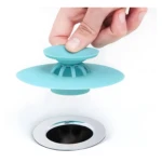 Tapa de silicona para tapón de desagüe multifunción en tina blanca.