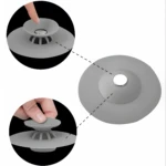 Tapón de silicona gris para desagüe de ducha o bañera, con botón para abrir y cerrar.