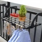 Tendedero de ropa plegable para balcón con zapatos rojos y planta de bambú.