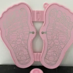 Tapete masajeador de pies rosado con diagrama de puntos de reflexología, ideal para terapia.