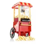 Máquina crispetera eléctrica roja sin aceite con palomitas de maíz.