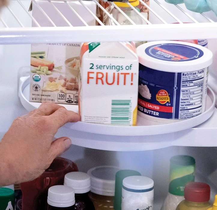 Estante esquinero giratorio para refrigerador con envase de jugo y mantequilla.