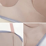 Masajeador eléctrico de senos en primer plano, tela suave, costuras y correa rosa.