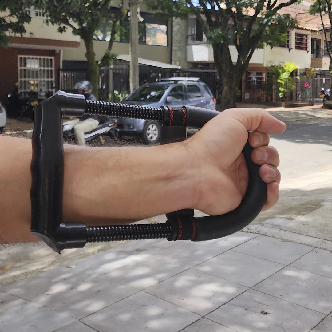 Ejercitador de mano para muñeca y antebrazo en uso por persona, diseño ergonómico.