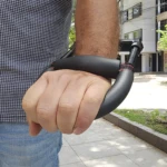 Puño cerrado sujetando ejercitador de mano para muñeca y antebrazo