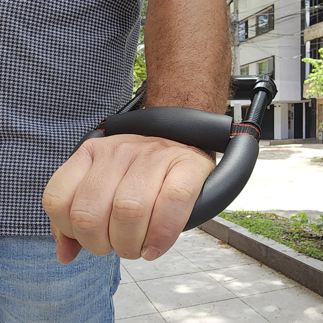 Puño cerrado sujetando ejercitador de mano para muñeca y antebrazo