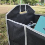 Organizador negro para carro o camping con un tablero azul y llaves en el interior.