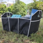 Organizador negro plegable para carro o camping con productos en su interior, al aire libre.