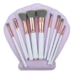 Set de brochas de maquillaje blancas y doradas en estuche morado con forma de concha.