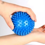 Bola de masaje azul con púas para yoga, 9 mm, en mano para terapia.