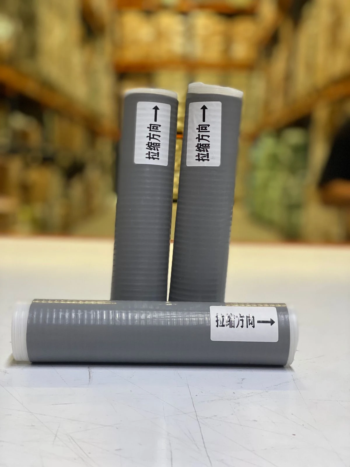 Fundas de silicona para ollas X3 con flechas indicando la dirección de estiramiento, color gris.