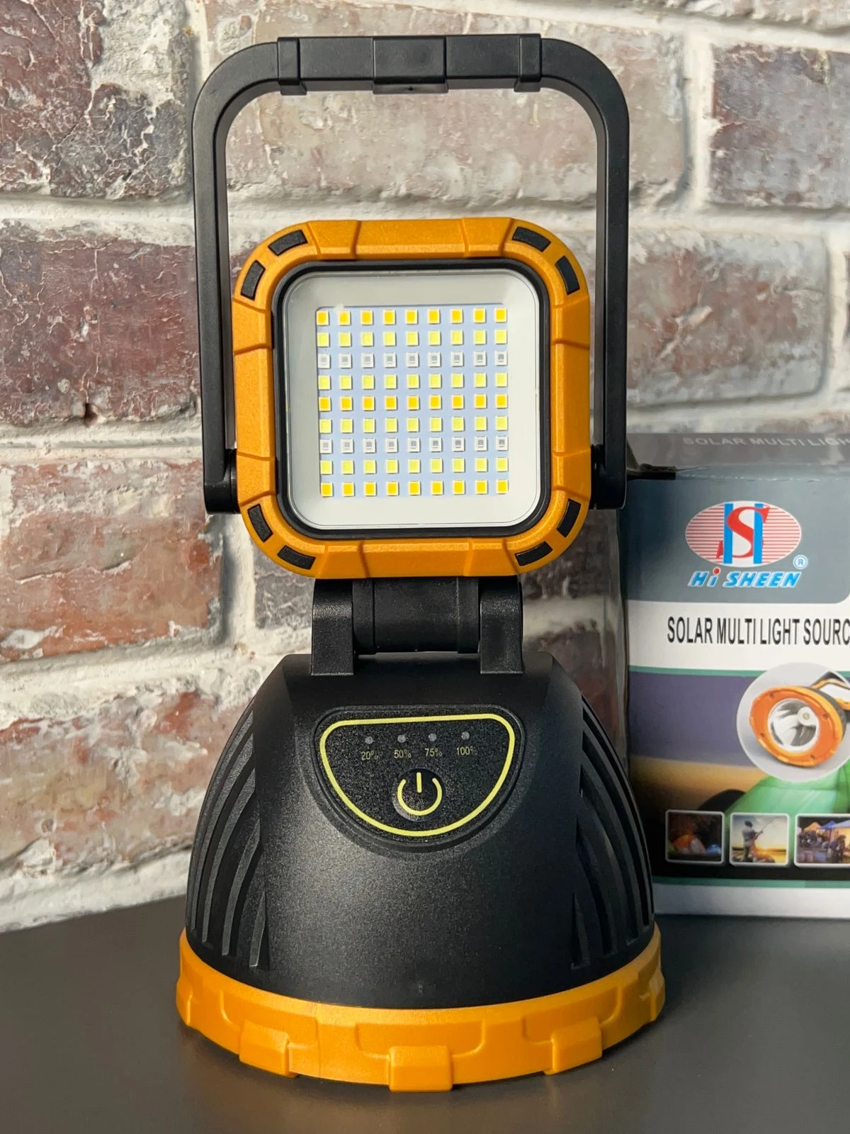 Linterna LED solar y USB para camping, portátil, luz de trabajo recargable, naranja y negro.