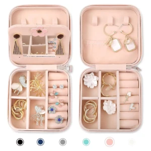 Joyero organizador rosa de viaje con múltiples compartimentos y joyas expuestas.