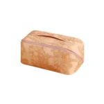 Cosmetiquera texturizada en tono rosado pálido con delicado diseño floral en relieve.