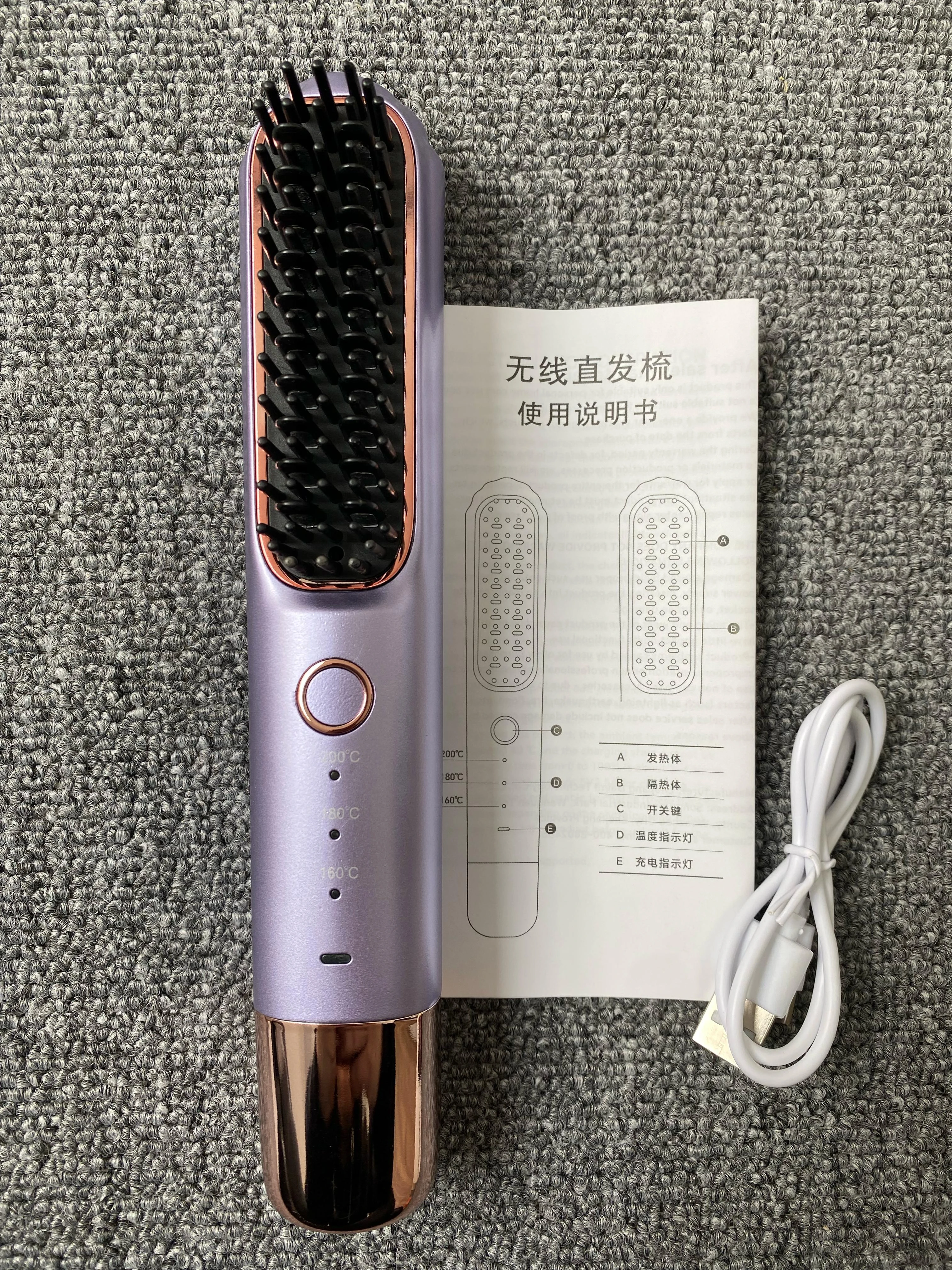 Cepillo alisador inalámbrico morado con cable USB y manual de instrucciones.